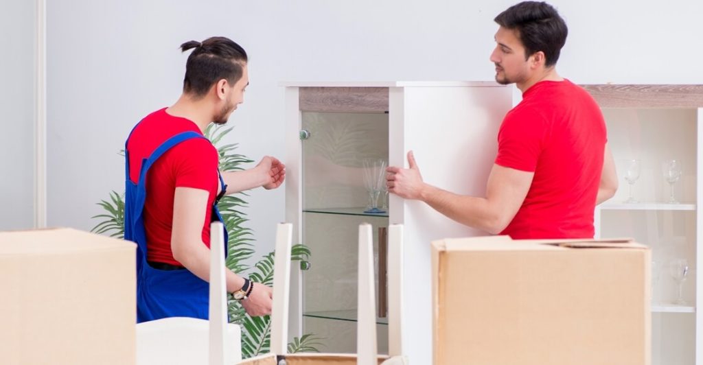 Professional movers preparing furniture for moving