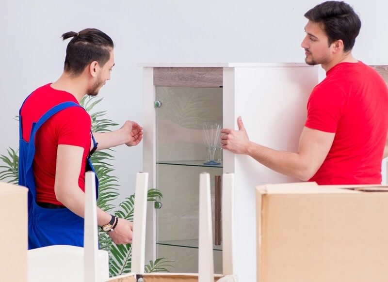 Professional movers preparing furniture for moving